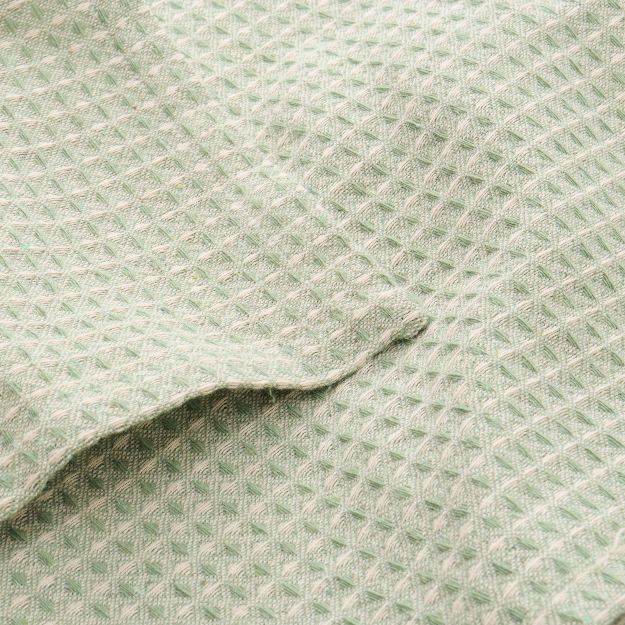 Minimal sage green waffle tablecloth styled on a contemporary dining table