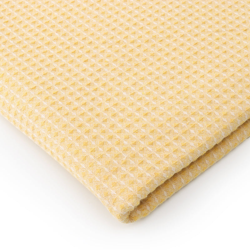 Soft yellow waffle texture table cover styled on a contemporary dining table