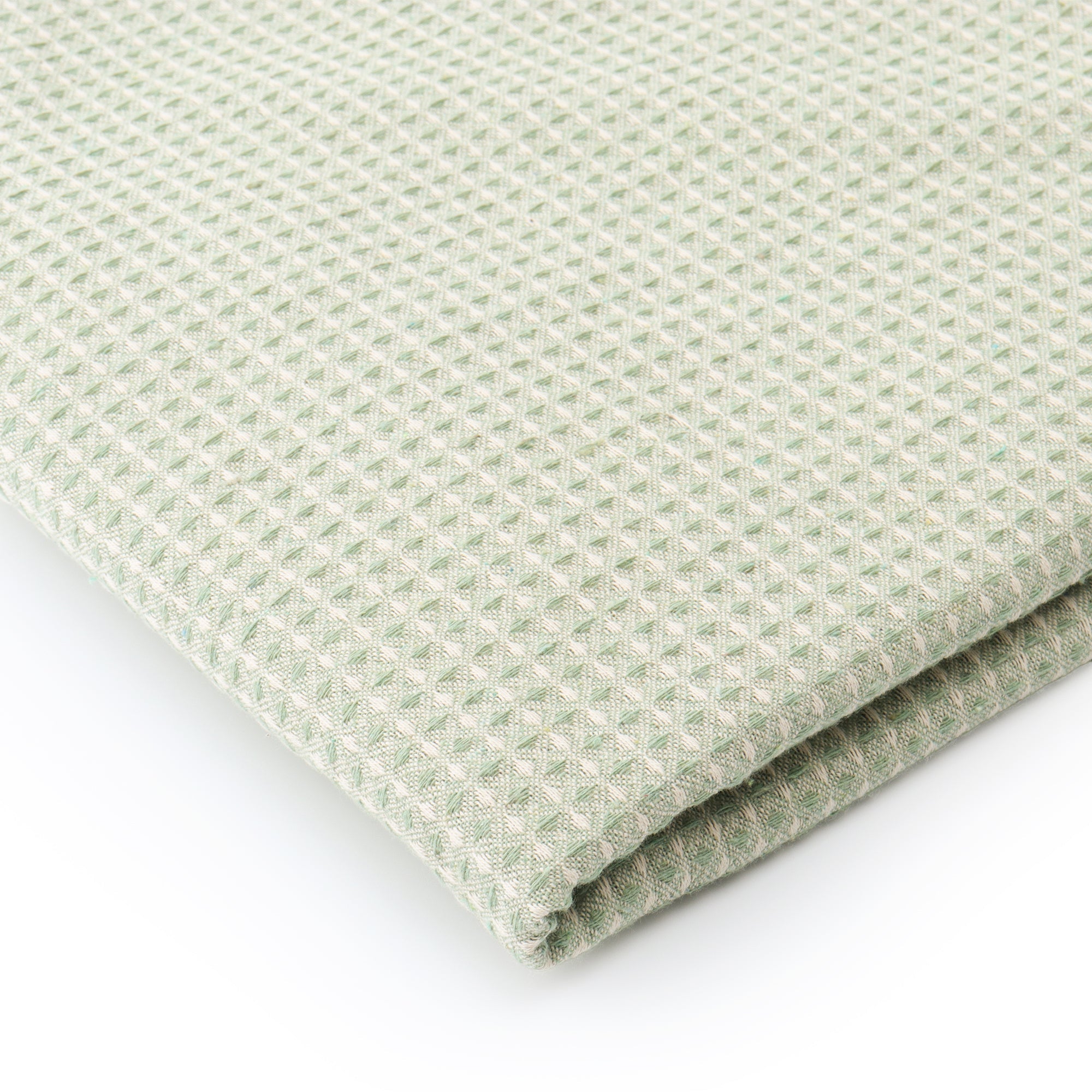 Sage green waffle texture dining table cover styled in a modern dining room