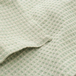 Minimal sage green waffle tablecloth styled on a contemporary dining table