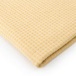 Soft yellow waffle texture table cover styled on a contemporary dining table