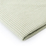 Sage green waffle texture dining table cover styled in a modern dining room